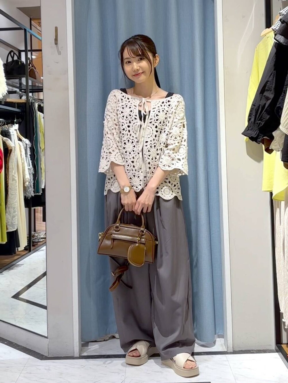 ブラック系のタンクトップ、ホワイト系のサンダル、ホワイト系のカーディガン/ボレロを着用したレディースの夏コーディネートの2枚目の写真