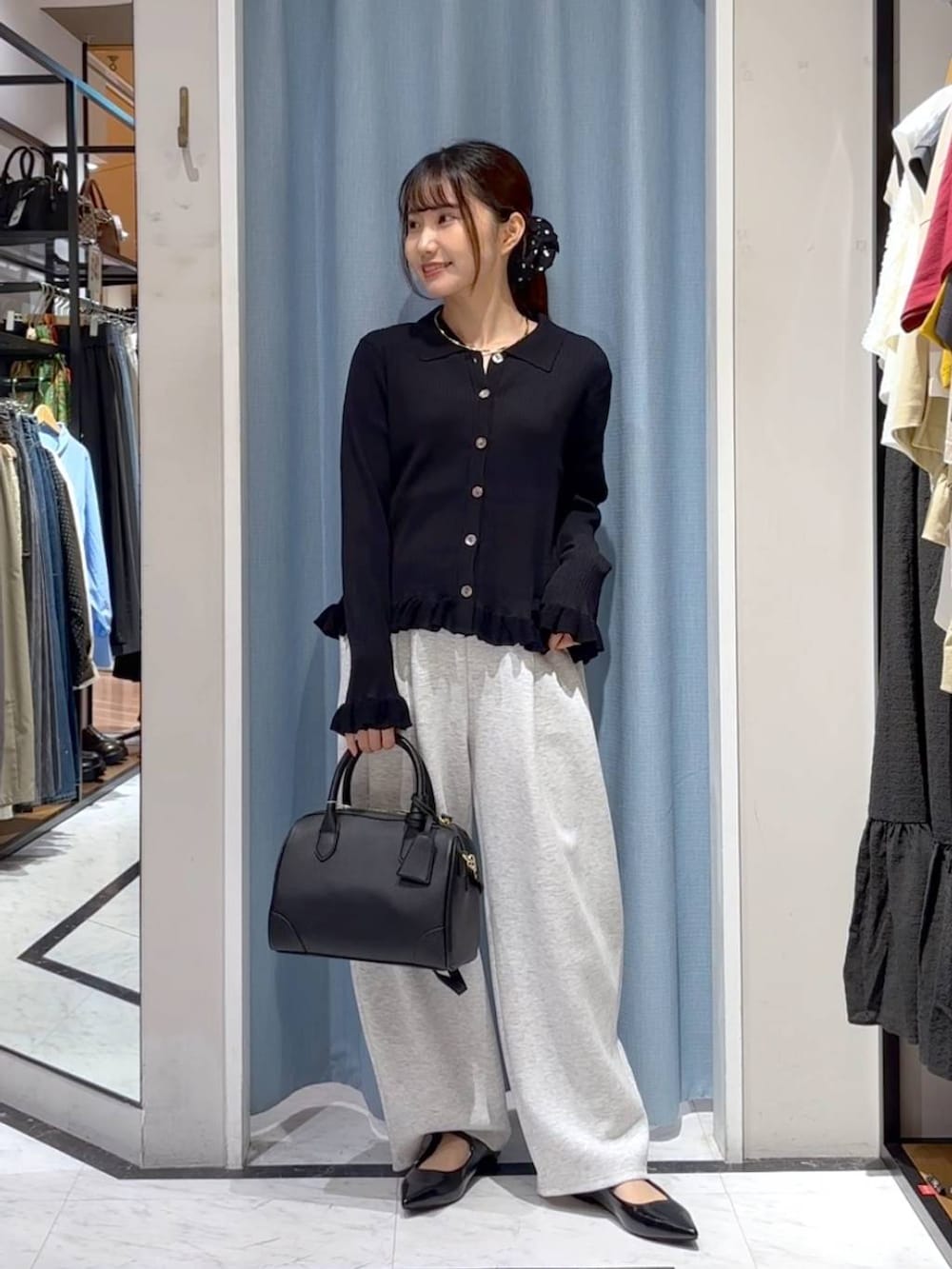 グレー系のスウェットパンツ、ブラック系のショルダーバッグ、ブラック系のニット/セーターを着用したレディースの秋コーディネートの4枚目の写真