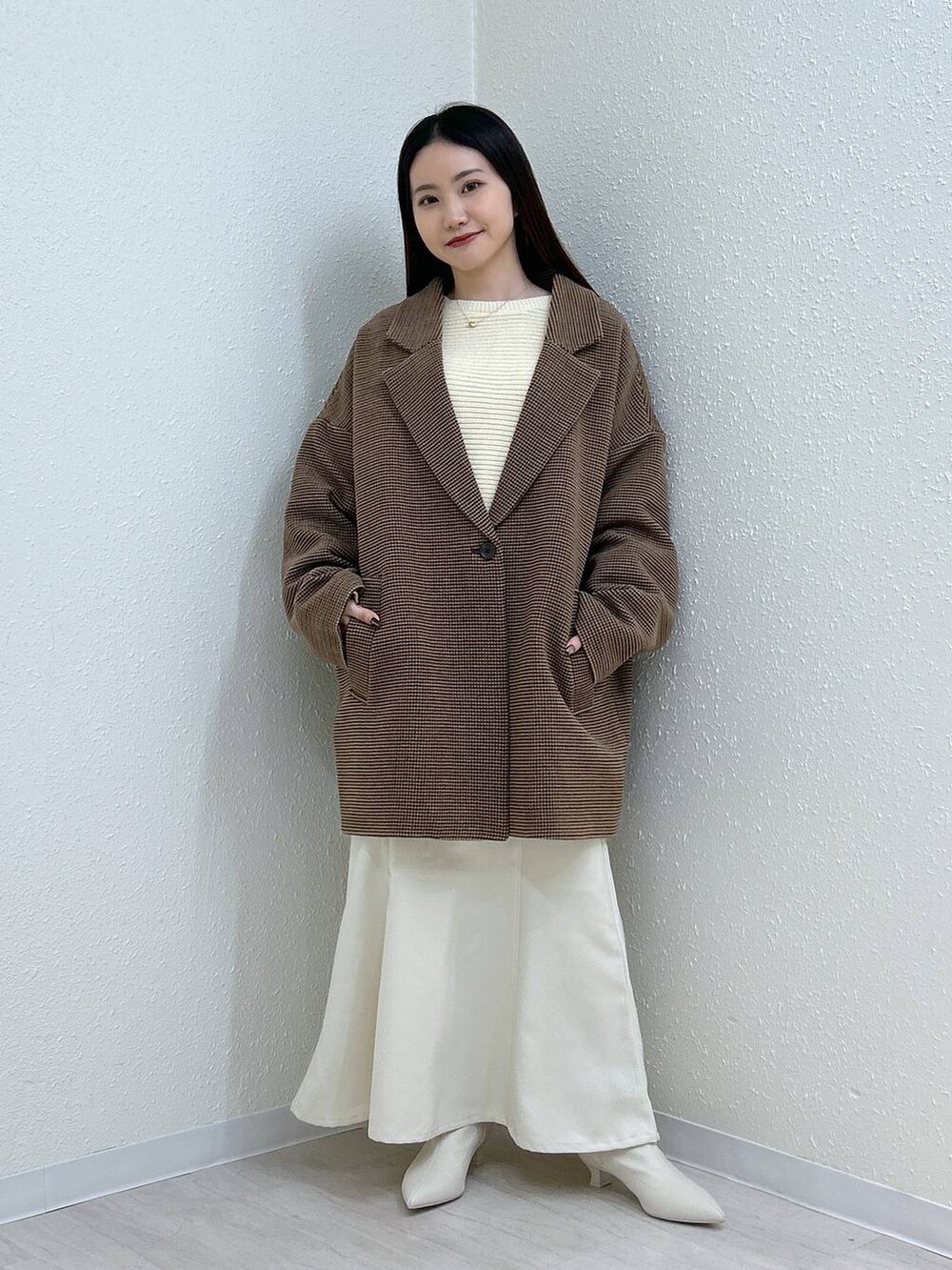 ホワイト系のスカート、ホワイト系のニット/セーター、その他のテーラードジャケットを着用したレディースの冬コーディネートの3枚目の写真