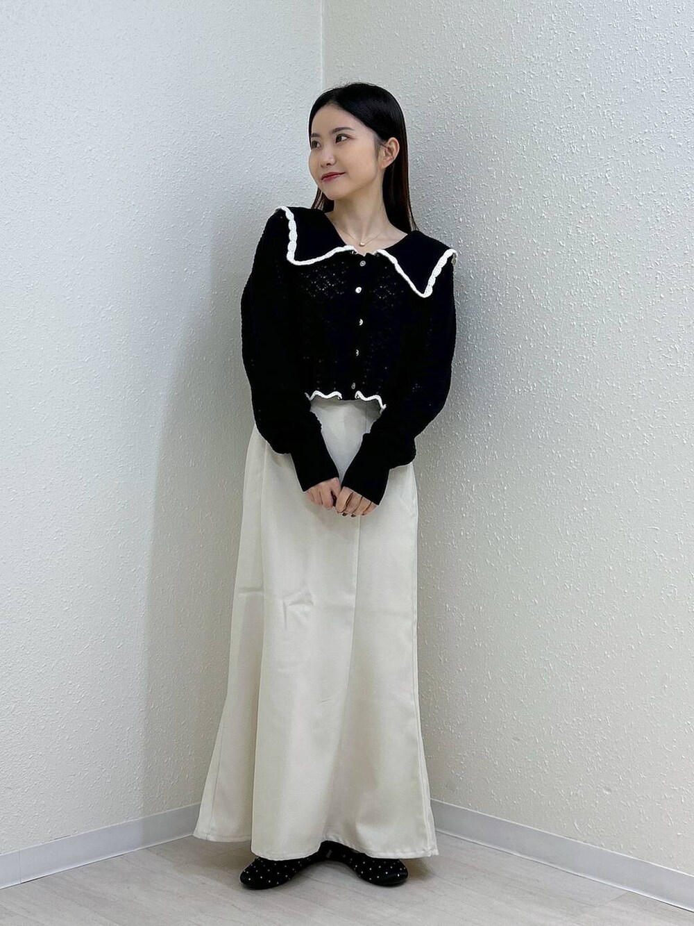 ホワイト系のスカート、ホワイト系のタンクトップ、ブラック系のバレエシューズを着用したレディースの秋コーディネートの3枚目の写真