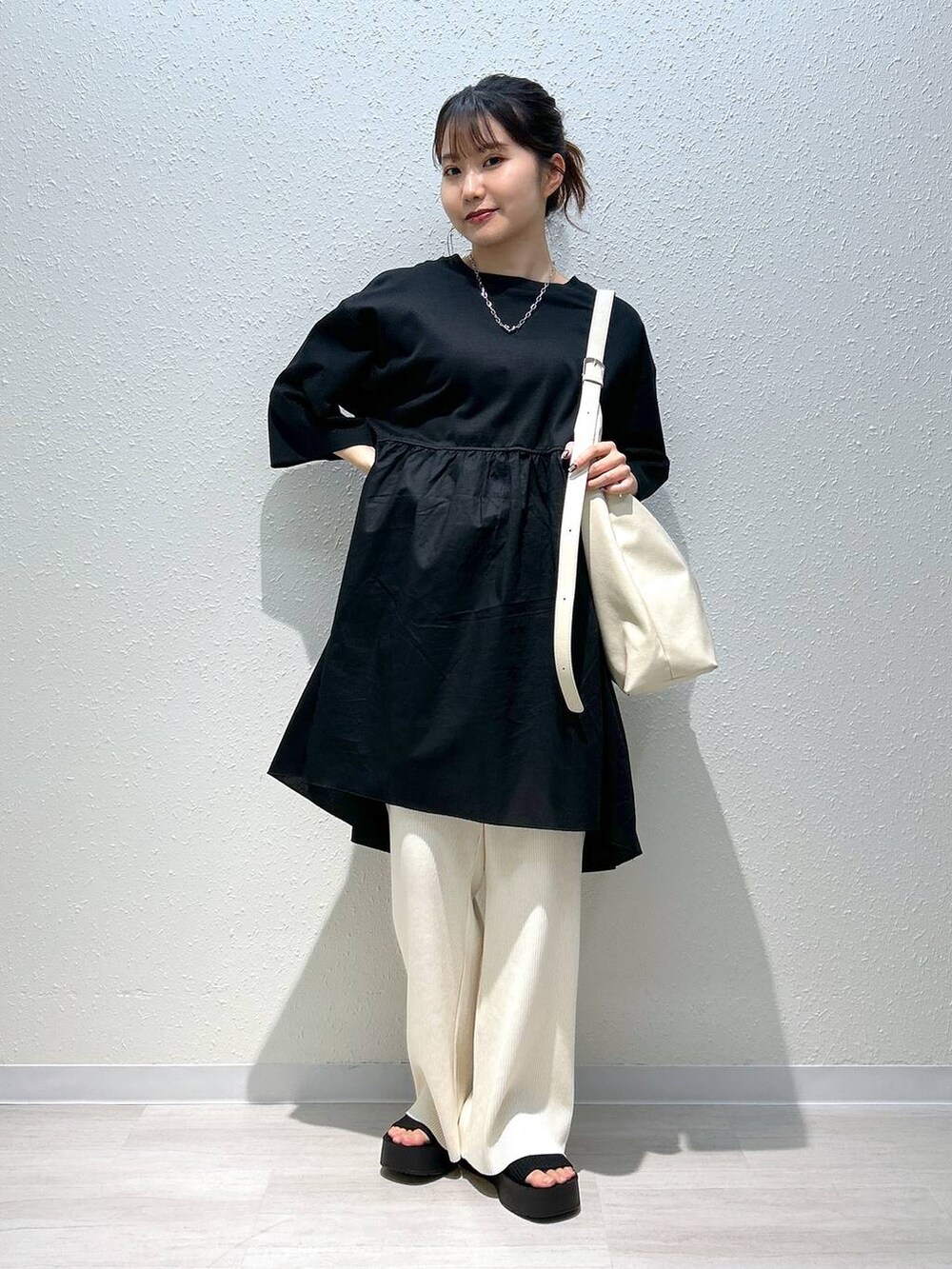 ブラック系のサンダル、ホワイト系のその他パンツ、ブラック系のTシャツ/カットソーを着用したレディースの春コーディネートの3枚目の写真