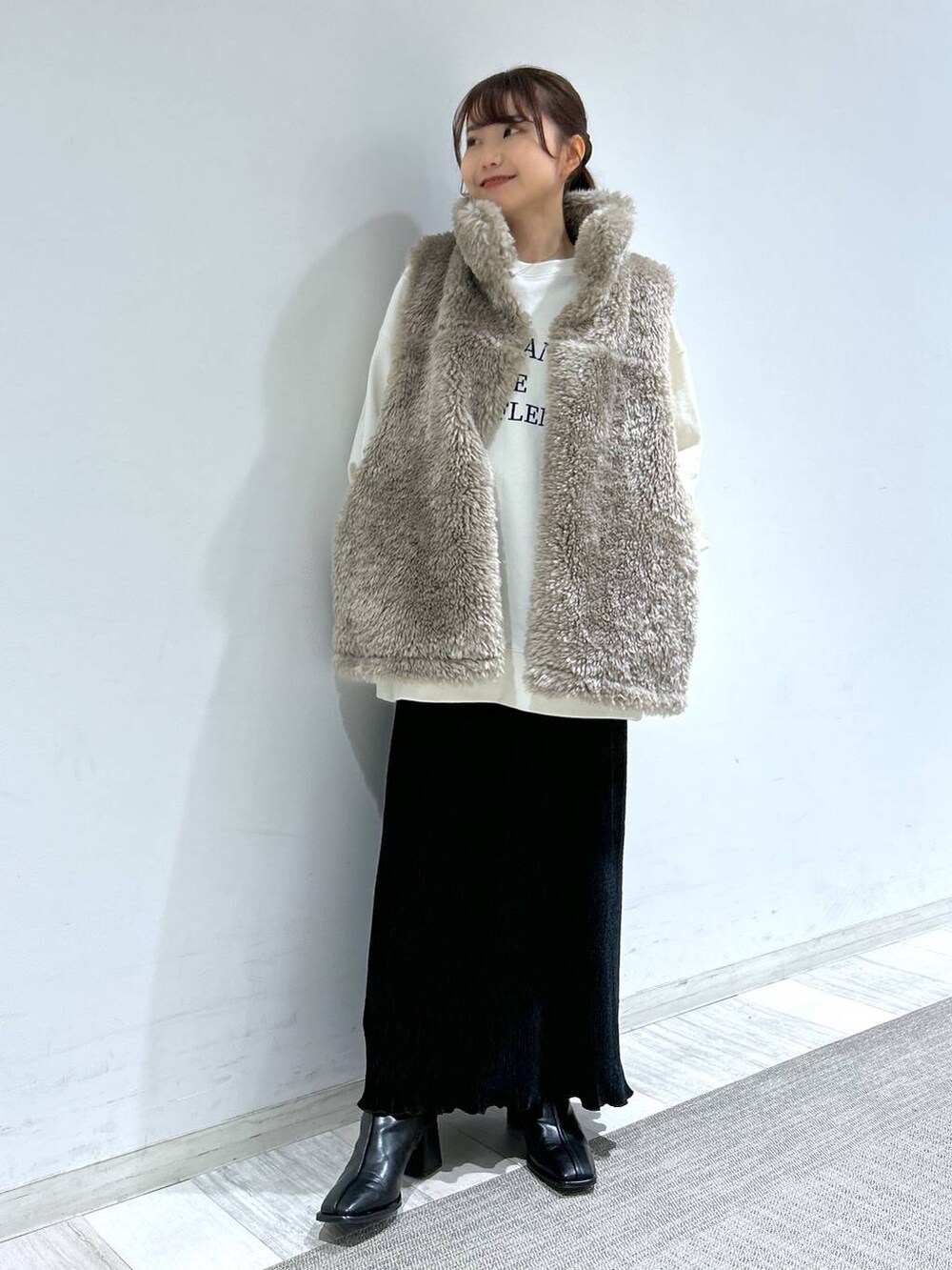 ホワイト系のブルゾン、ブラック系のパンプス、ブラック系のスカートを着用したレディースの冬コーディネートの4枚目の写真