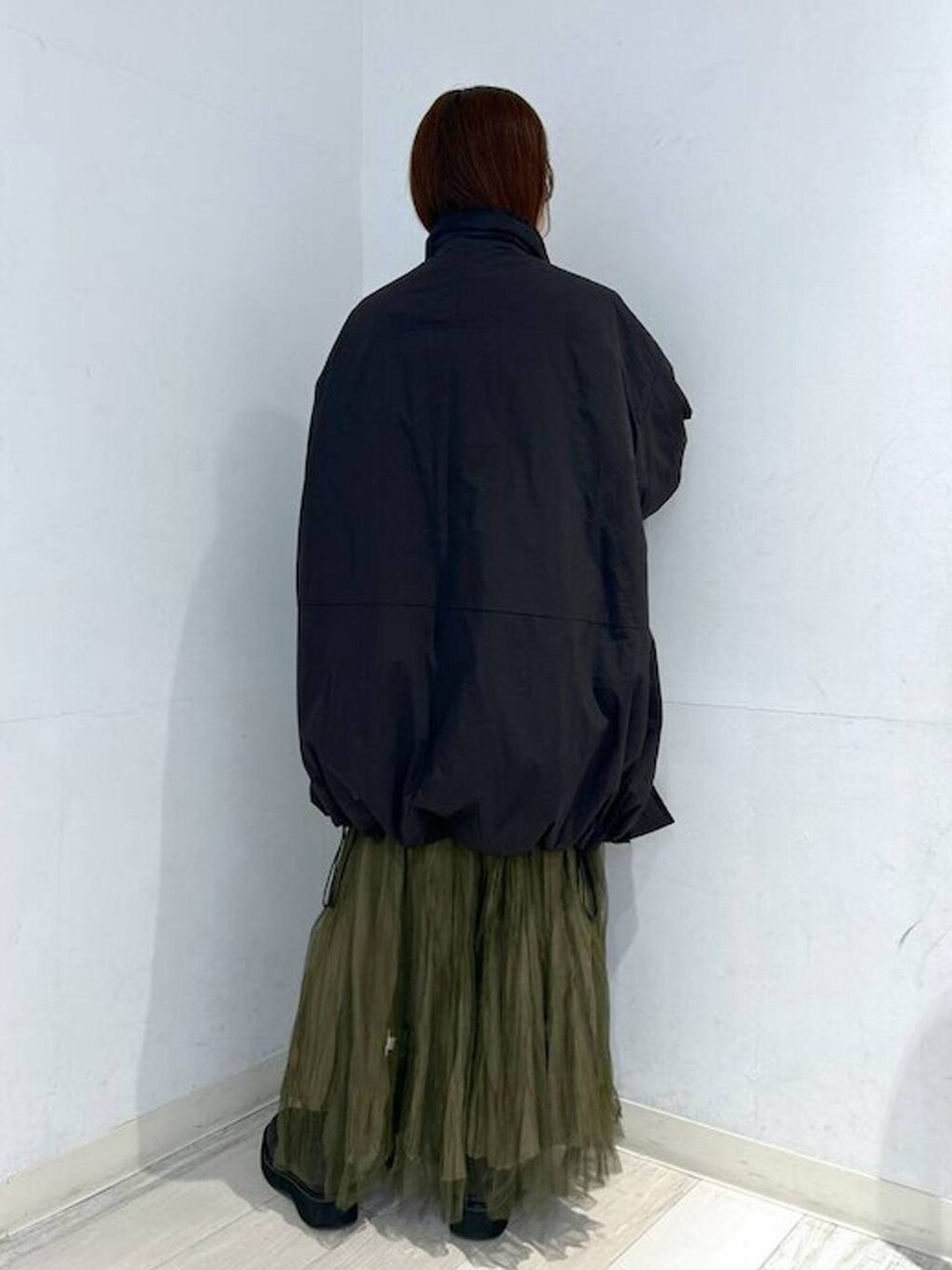 ブラック系のダウンジャケット/コート、ブラック系のブーツ、ホワイト系のTシャツ/カットソーを着用したレディースの冬コーディネートの8枚目の写真