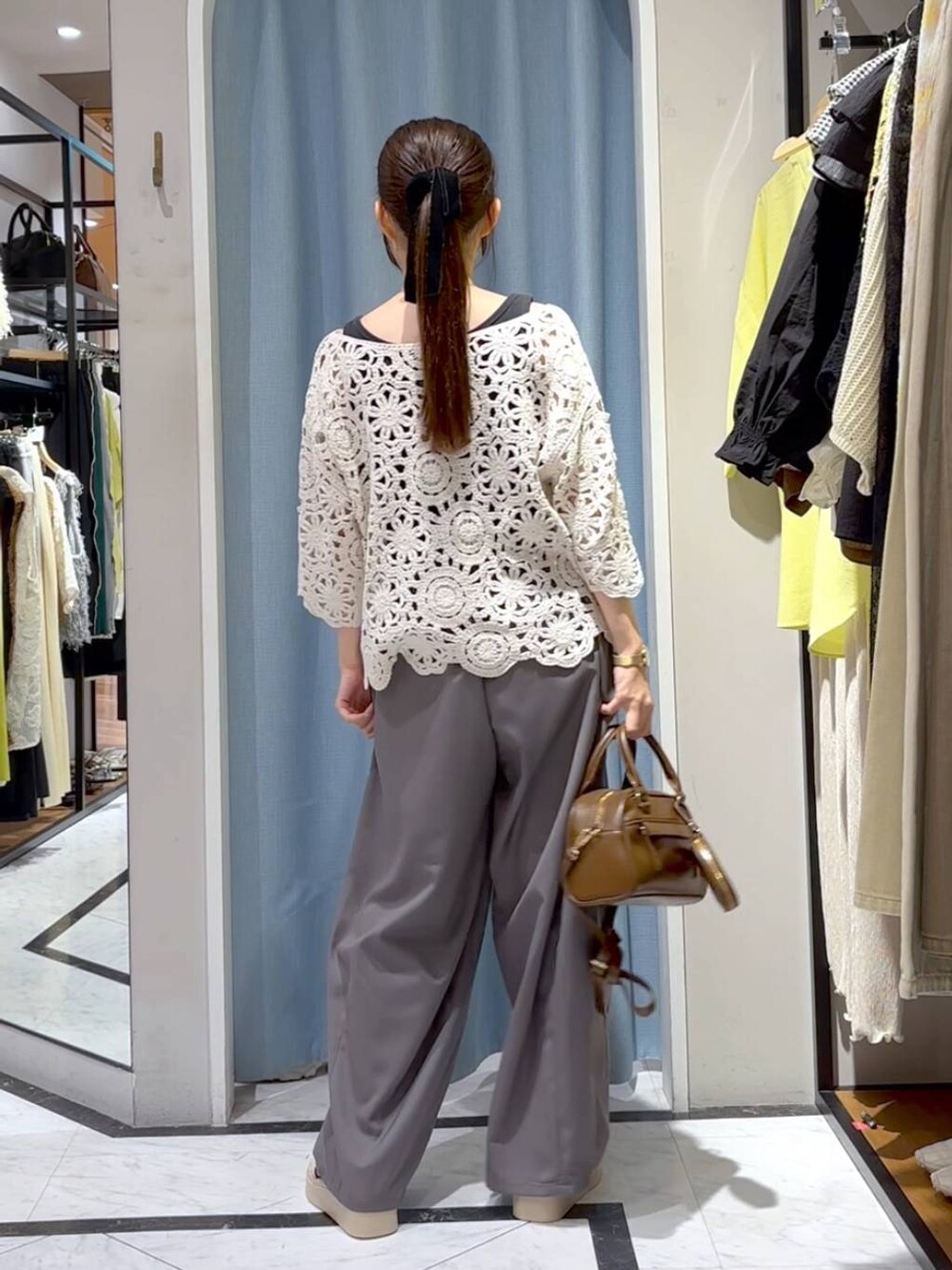 ブラック系のタンクトップ、ホワイト系のサンダル、ホワイト系のカーディガン/ボレロを着用したレディースの夏コーディネートの7枚目の写真