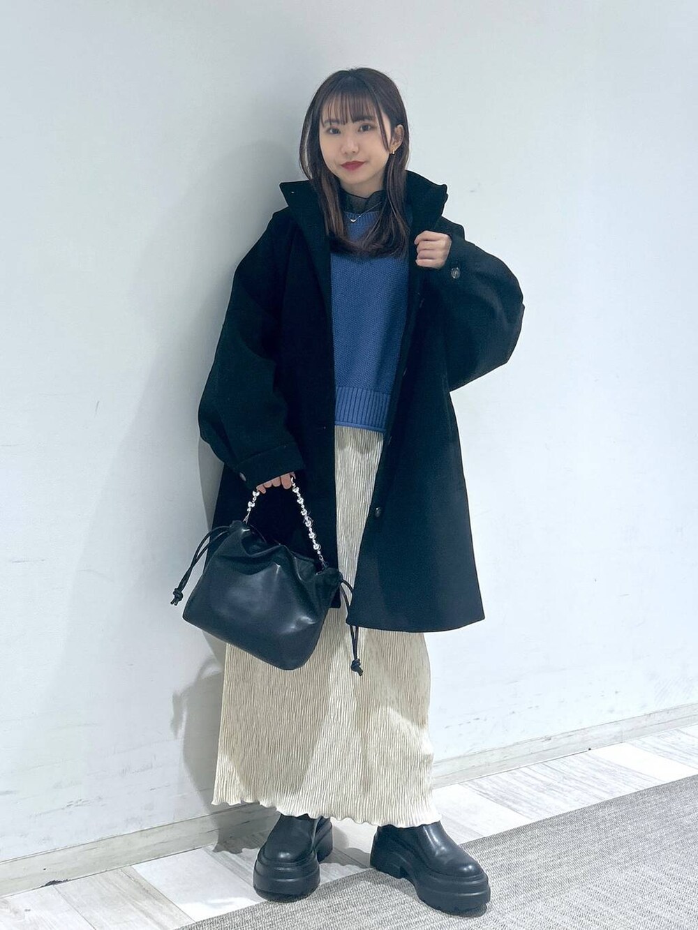 ブラック系のその他アウター、ブルー系のTシャツ/カットソー、ブラック系のブーツを着用したレディースの冬コーディネートの2枚目の写真