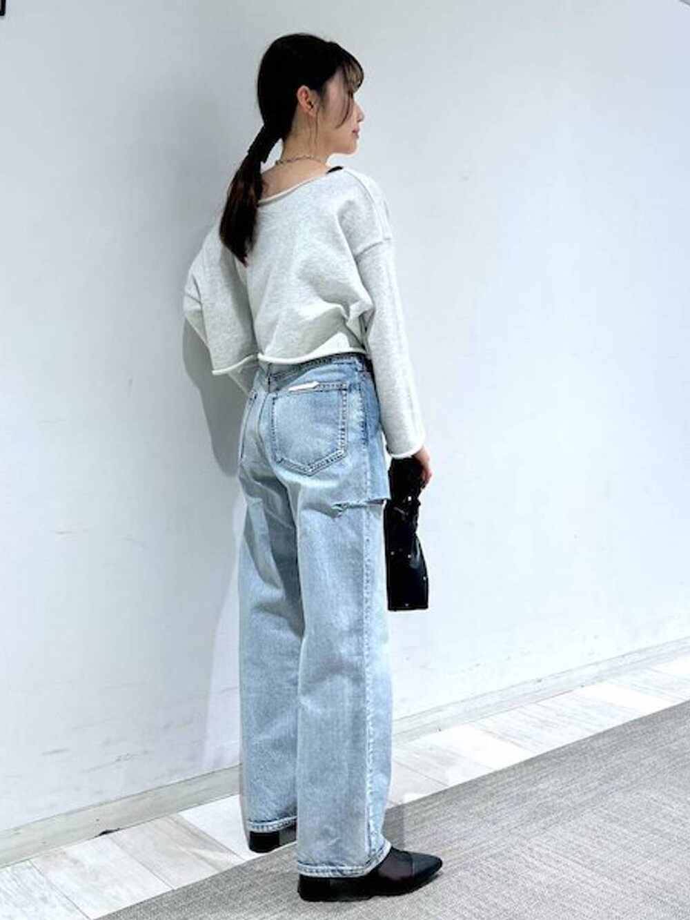 ブラック系のハンドバッグ、ブラック系のタンクトップ、ブルー系のデニムパンツを着用したレディースの冬コーディネートの6枚目の写真