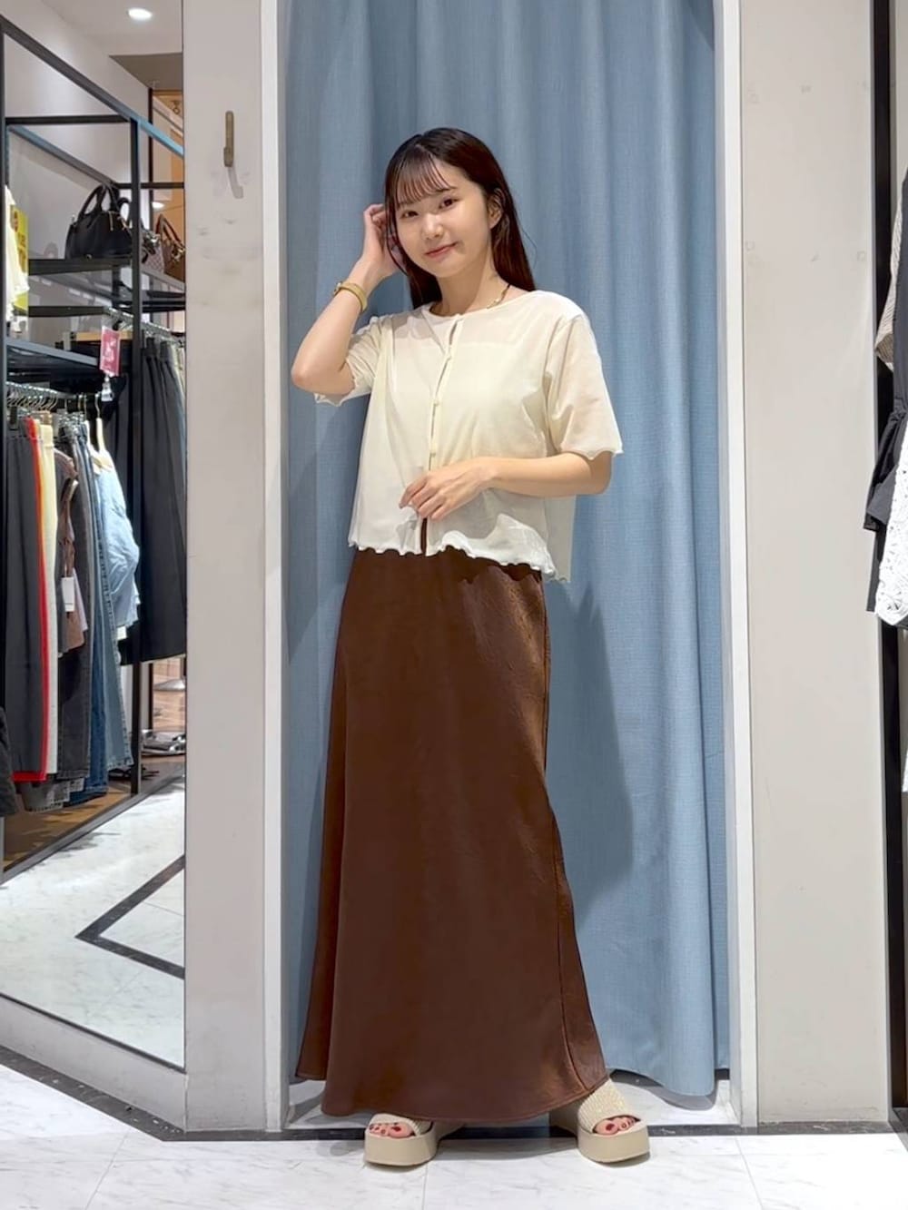 ホワイト系のTシャツ/カットソー、ホワイト系のサンダル、ブラウン系のスカートを着用したレディースの秋コーディネートの2枚目の写真