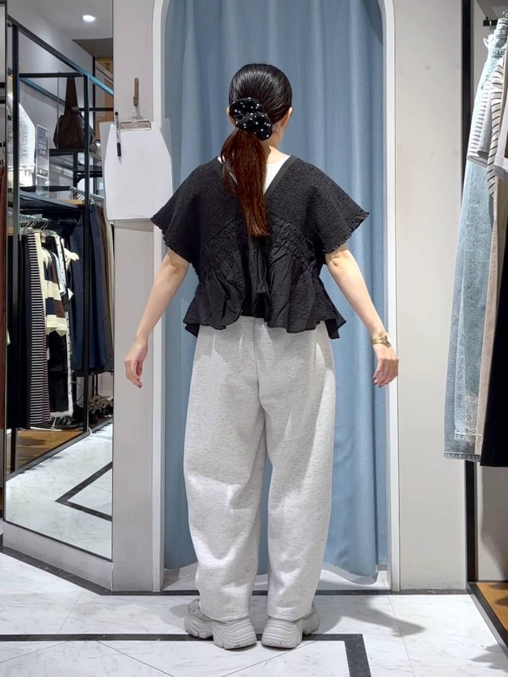 グレー系のスウェットパンツ、ブラック系のシャツ/ブラウス、シルバー系のスニーカーを着用したレディースの夏コーディネートの5枚目の写真
