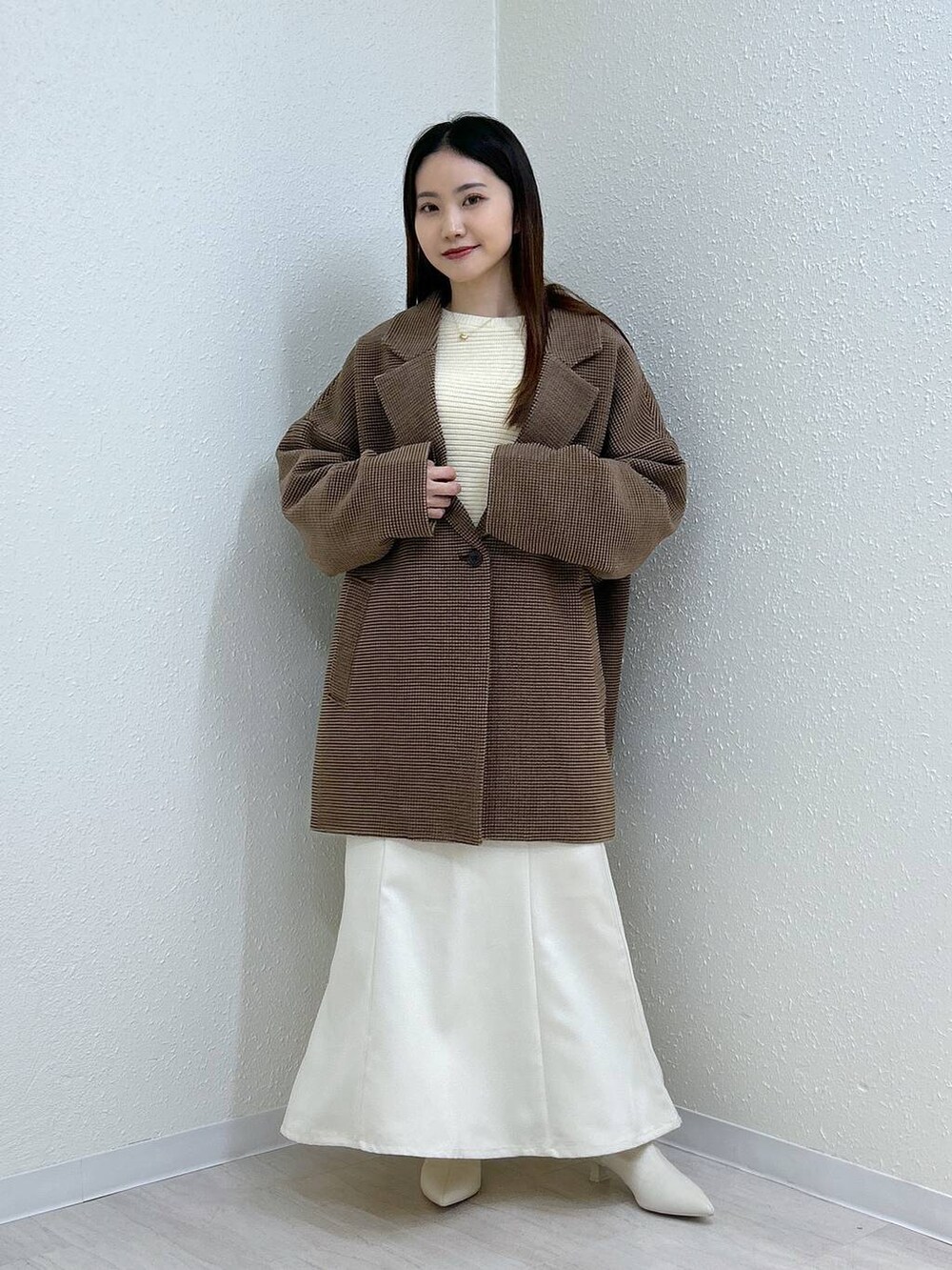 ホワイト系のスカート、ホワイト系のニット/セーター、その他のテーラードジャケットを着用したレディースの冬コーディネートの6枚目の写真