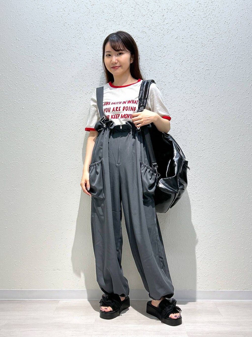 ブラック系のサンダル、ホワイト系のTシャツ/カットソー、ブラック系のショルダーバッグを着用したレディースの夏コーディネートの4枚目の写真