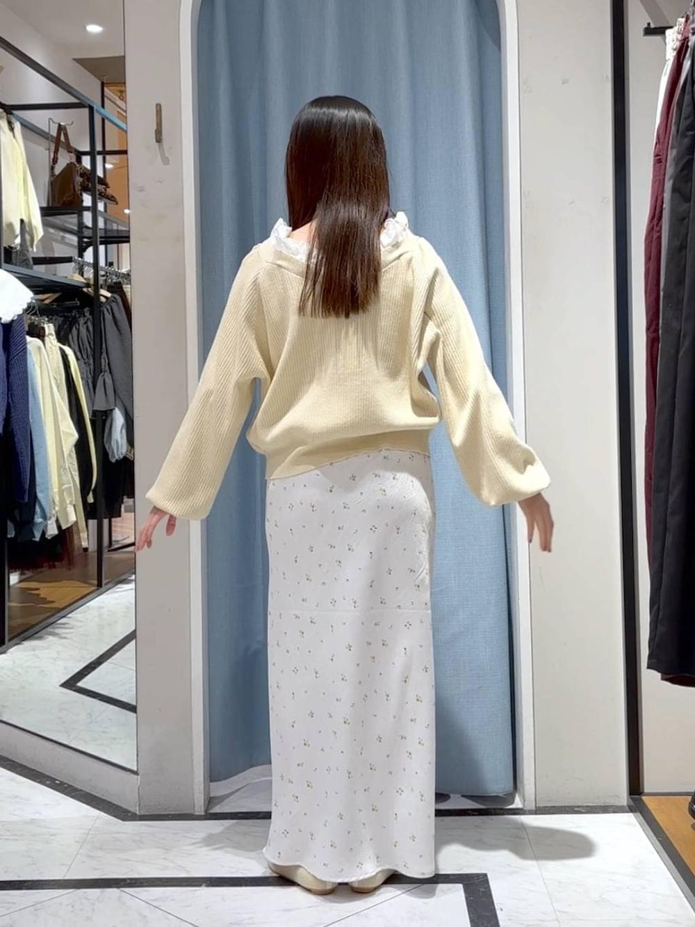 ホワイト系のスカート、ホワイト系のパンプス、ベージュ系のカーディガン/ボレロを着用したレディースの春コーディネートの6枚目の写真