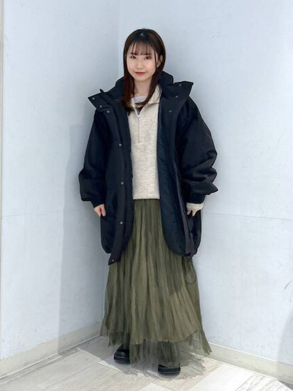 ブラック系のダウンジャケット/コート、ブラック系のブーツ、ホワイト系のTシャツ/カットソーを着用したレディースの冬コーディネートの5枚目の写真