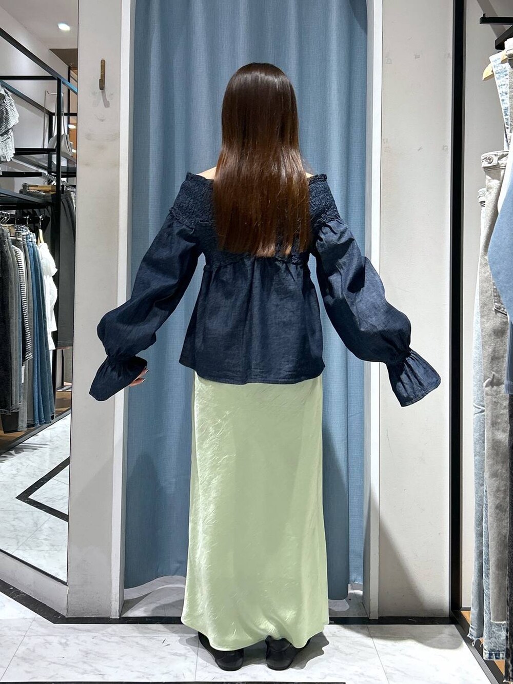 ブルー系のシャツ/ブラウス、ブラック系のスニーカー、グリーン系のスカートを着用したレディースの春コーディネートの6枚目の写真