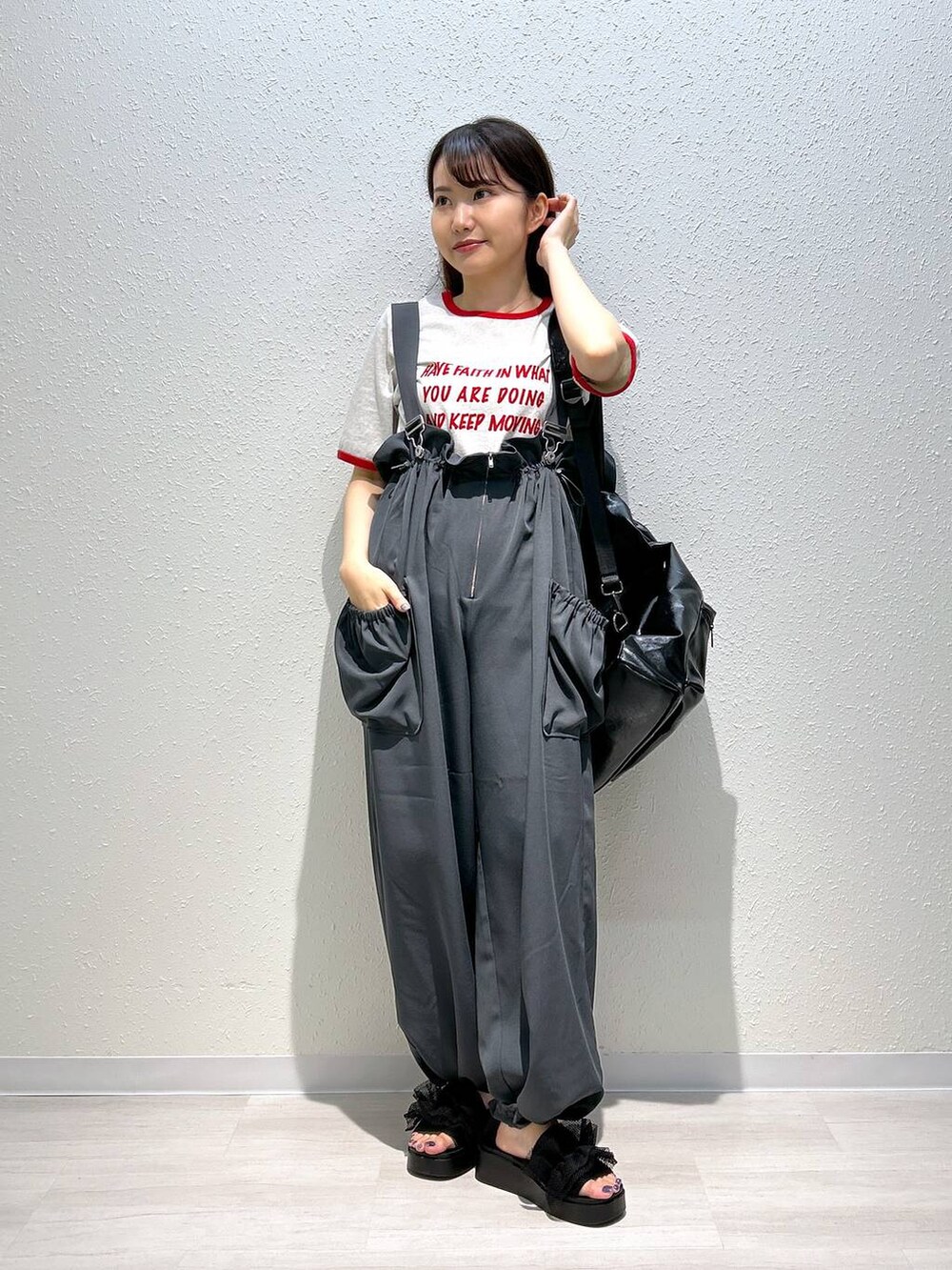 ブラック系のサンダル、ホワイト系のTシャツ/カットソー、ブラック系のショルダーバッグを着用したレディースの夏コーディネートの3枚目の写真