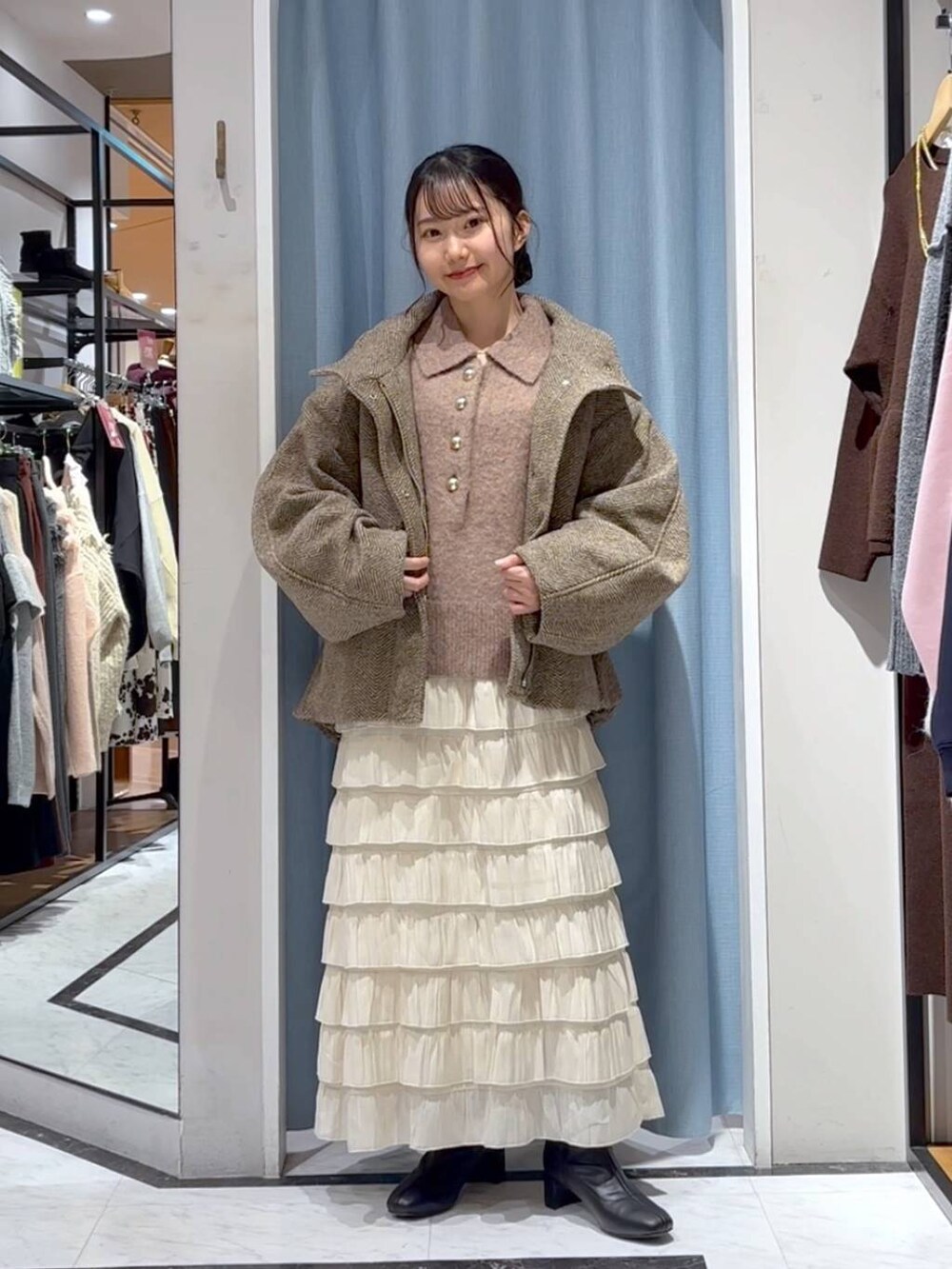 ベージュ系のブルゾン、ホワイト系のスカート、ブラウン系のニット/セーターを着用したレディースの冬コーディネートの4枚目の写真