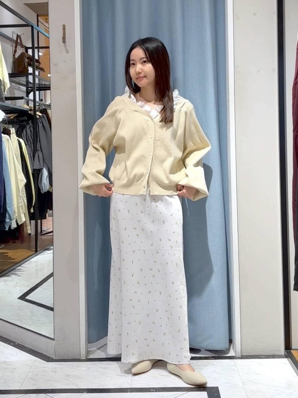 ホワイト系のスカート、ホワイト系のパンプス、ベージュ系のカーディガン/ボレロを着用したレディースの春コーディネートの3枚目の写真