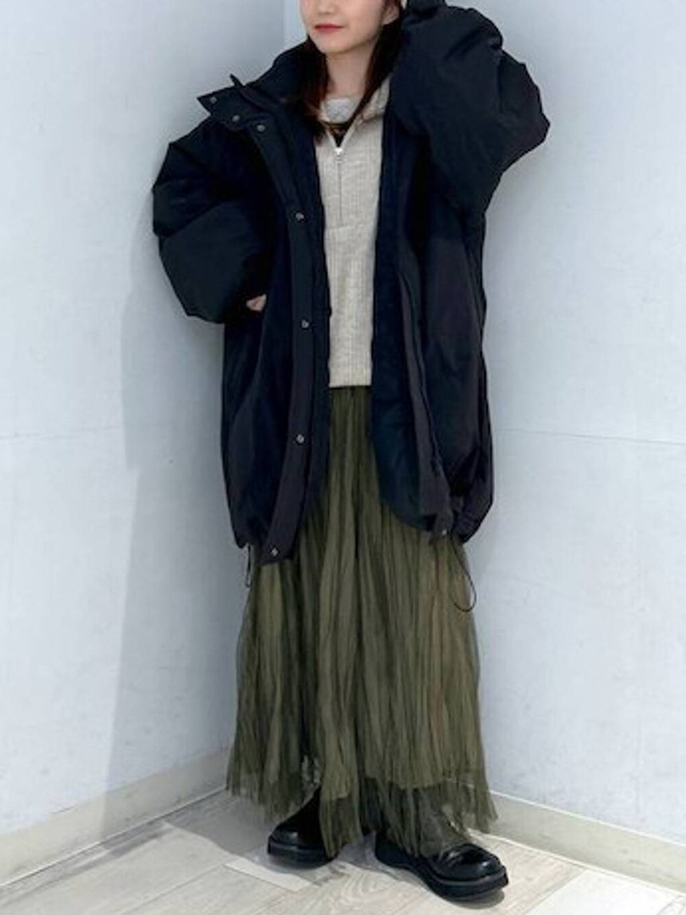 ブラック系のダウンジャケット/コート、ブラック系のブーツ、ホワイト系のTシャツ/カットソーを着用したレディースの冬コーディネートの4枚目の写真