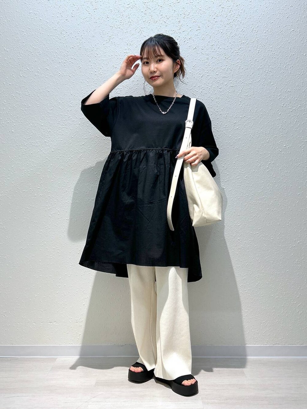 ブラック系のサンダル、ホワイト系のその他パンツ、ブラック系のTシャツ/カットソーを着用したレディースの春コーディネートの2枚目の写真