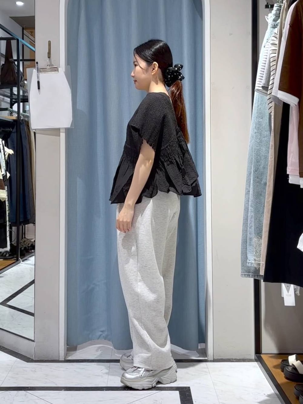 グレー系のスウェットパンツ、ブラック系のシャツ/ブラウス、シルバー系のスニーカーを着用したレディースの夏コーディネートの4枚目の写真