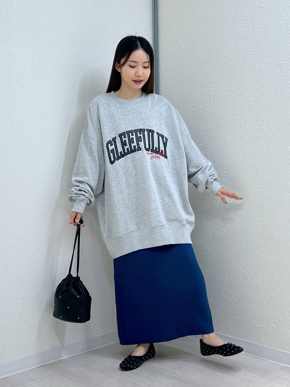 ブラック系のスカート、ブラック系のショルダーバッグ、ブラック系のバレエシューズを着用したレディースの秋コーディネートの5枚目の写真