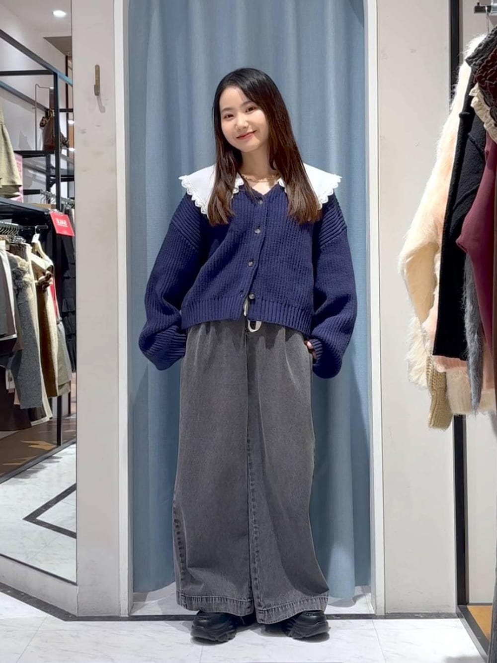 ブラック系のデニムパンツ、ブラック系のローファー、ブルー系のカーディガン/ボレロを着用したレディースの冬コーディネートの3枚目の写真