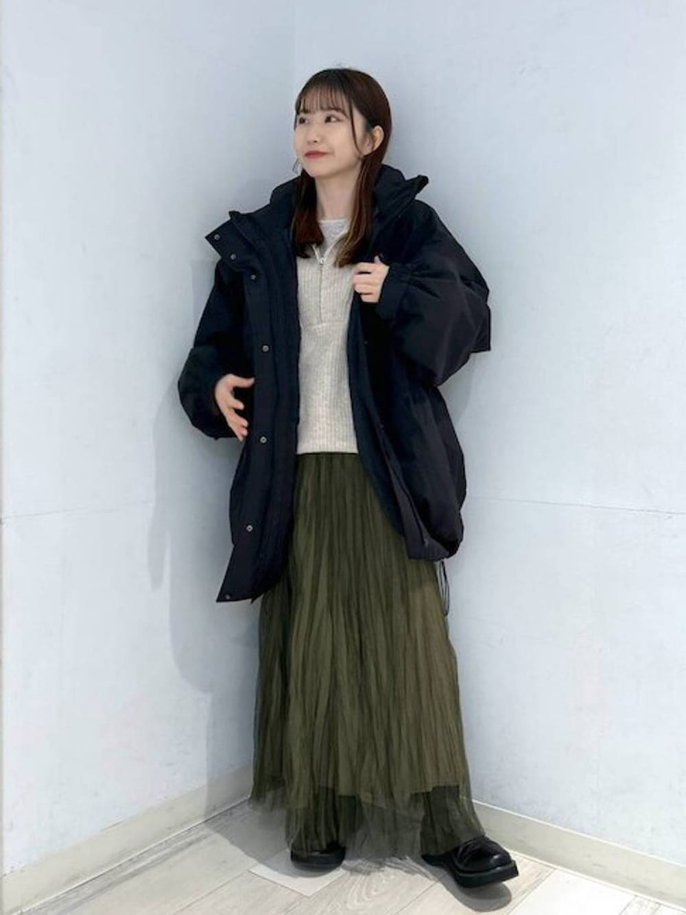 ブラック系のダウンジャケット/コート、ブラック系のブーツ、ホワイト系のTシャツ/カットソーを着用したレディースの冬コーディネートの3枚目の写真