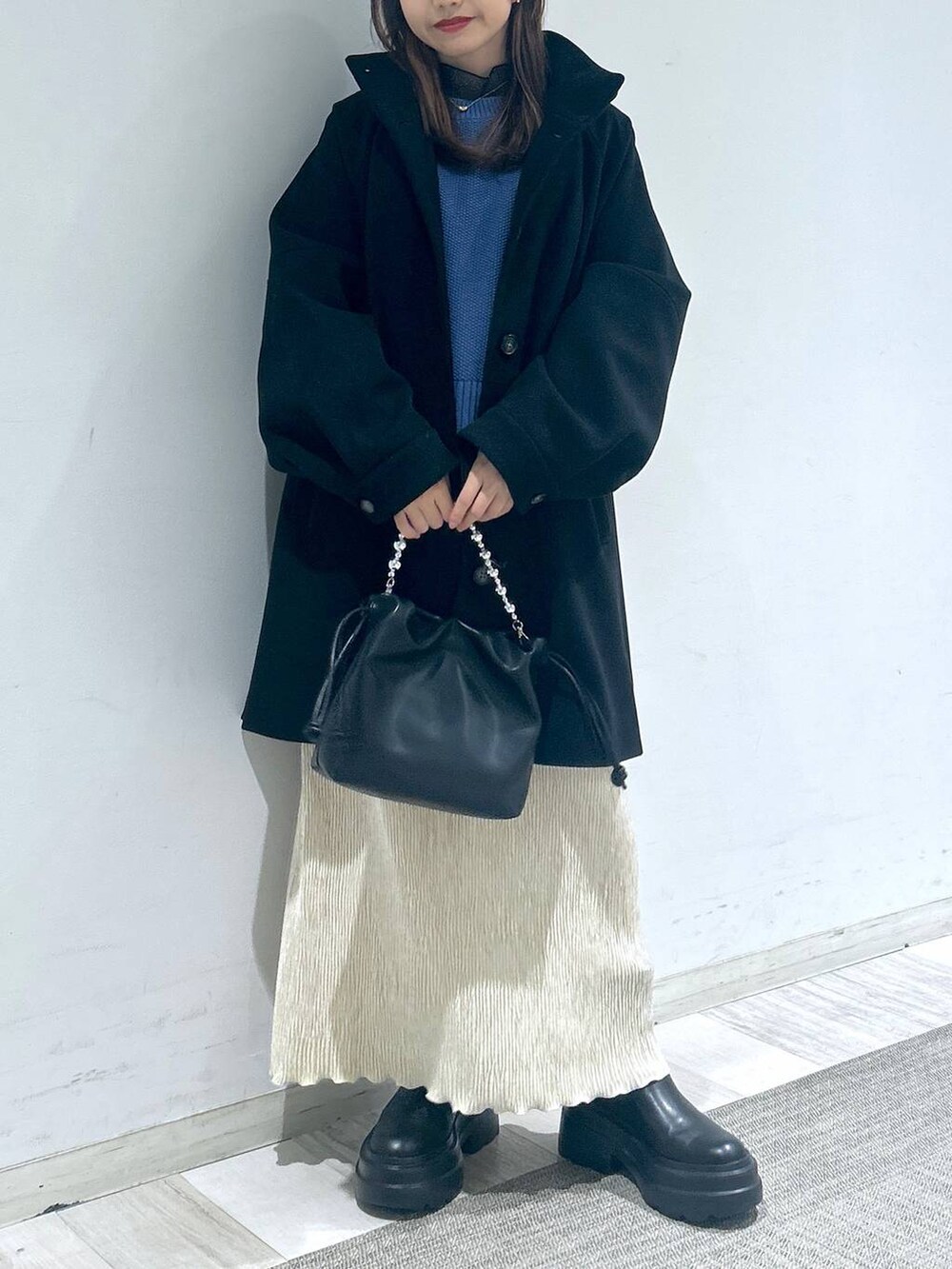 ブラック系のその他アウター、ブルー系のTシャツ/カットソー、ブラック系のブーツを着用したレディースの冬コーディネートの4枚目の写真