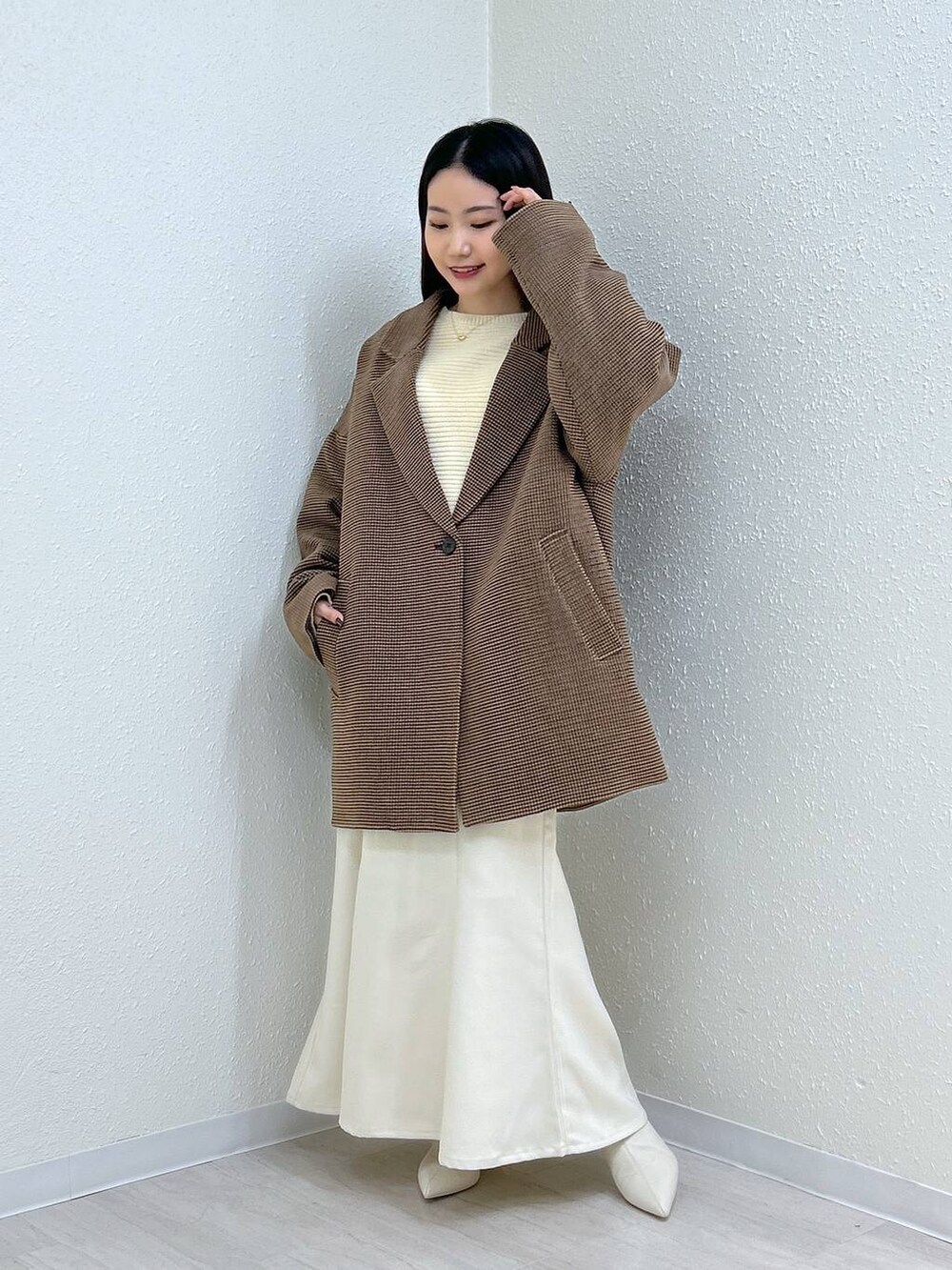 ホワイト系のスカート、ホワイト系のニット/セーター、その他のテーラードジャケットを着用したレディースの冬コーディネートの4枚目の写真