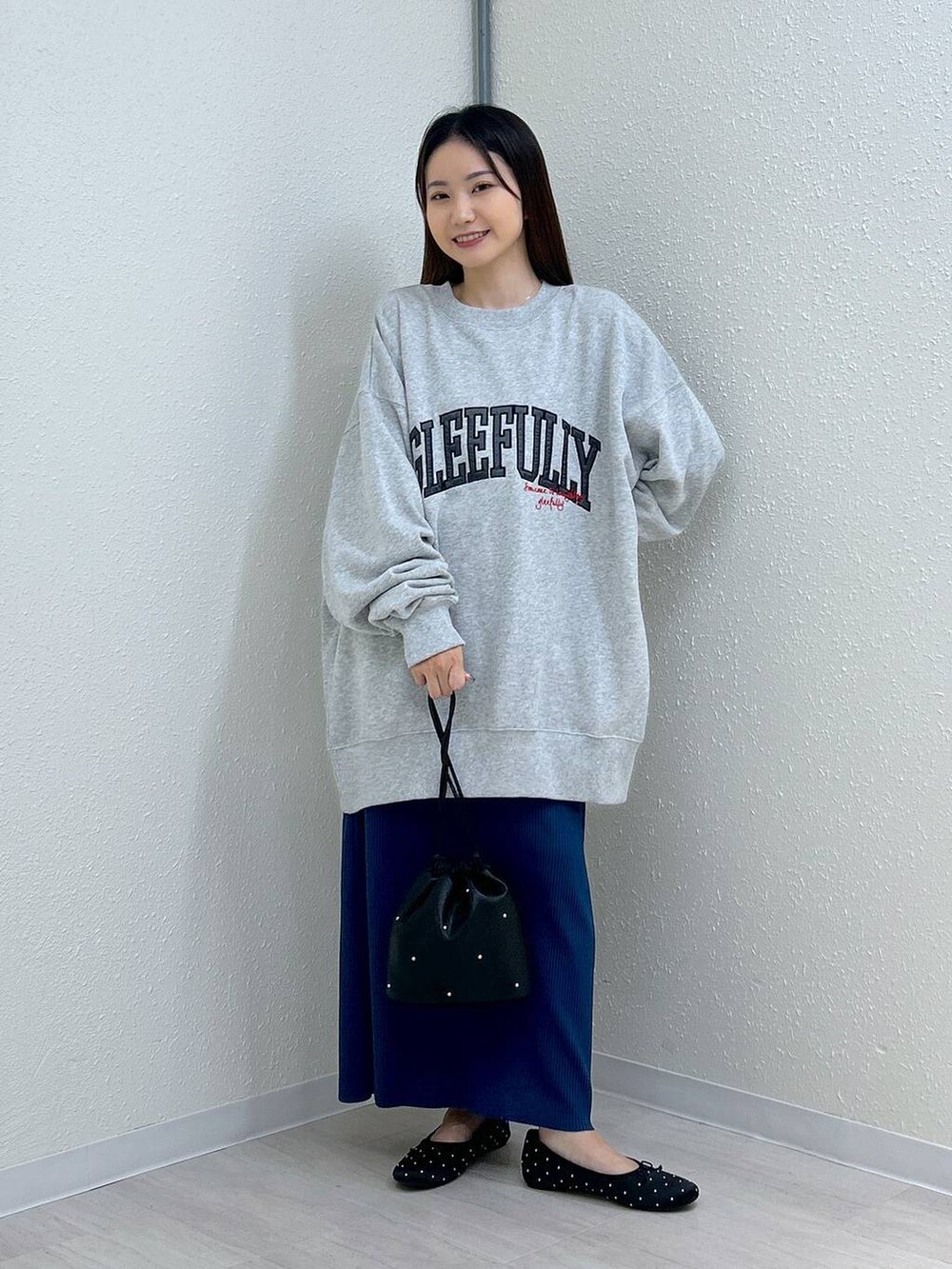 ブラック系のスカート、ブラック系のショルダーバッグ、ブラック系のバレエシューズを着用したレディースの秋コーディネートの6枚目の写真