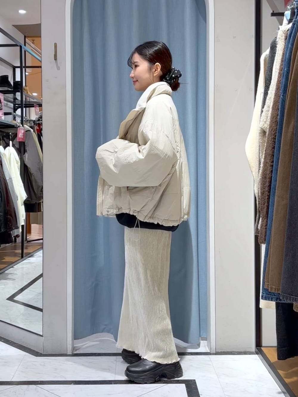 ホワイト系のその他アウター、ブラック系のブーツ、ホワイト系のスカートを着用したレディースの冬コーディネートの4枚目の写真