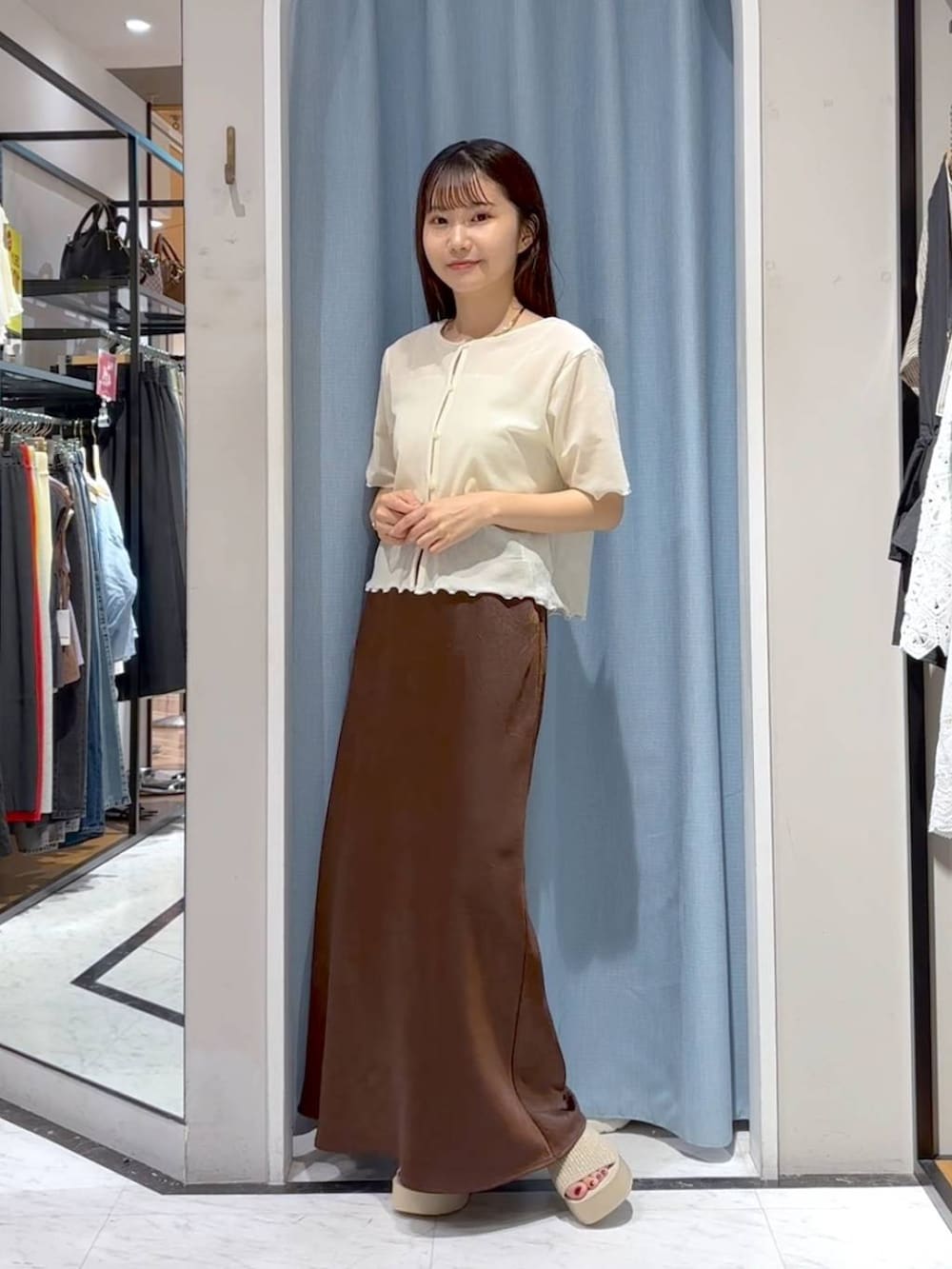 ホワイト系のTシャツ/カットソー、ホワイト系のサンダル、ブラウン系のスカートを着用したレディースの秋コーディネートの4枚目の写真