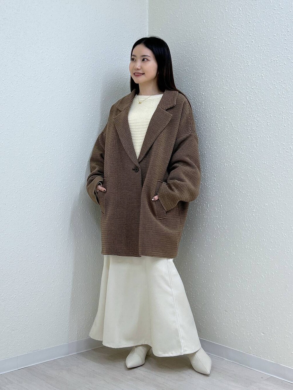 ホワイト系のスカート、ホワイト系のニット/セーター、その他のテーラードジャケットを着用したレディースの冬コーディネートの2枚目の写真