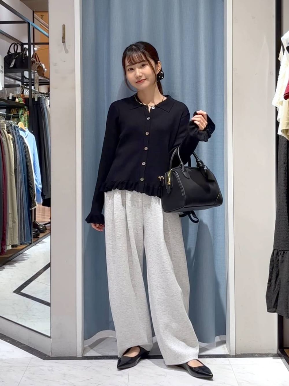 グレー系のスウェットパンツ、ブラック系のショルダーバッグ、ブラック系のニット/セーターを着用したレディースの秋コーディネートの5枚目の写真