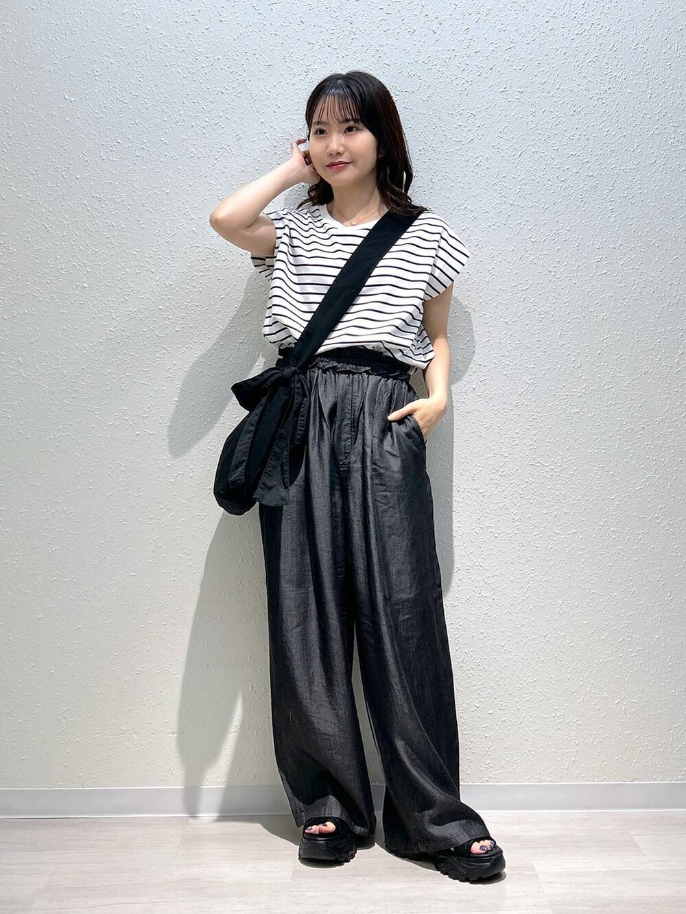 ブラック系のサンダル、ブラック系のデニムパンツ、ブラック系のTシャツ/カットソーを着用したレディースの夏コーディネートの4枚目の写真