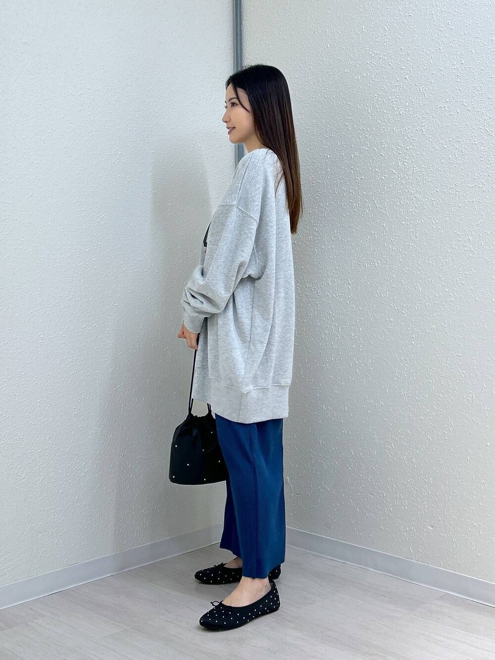 ブラック系のスカート、ブラック系のショルダーバッグ、ブラック系のバレエシューズを着用したレディースの秋コーディネートの7枚目の写真