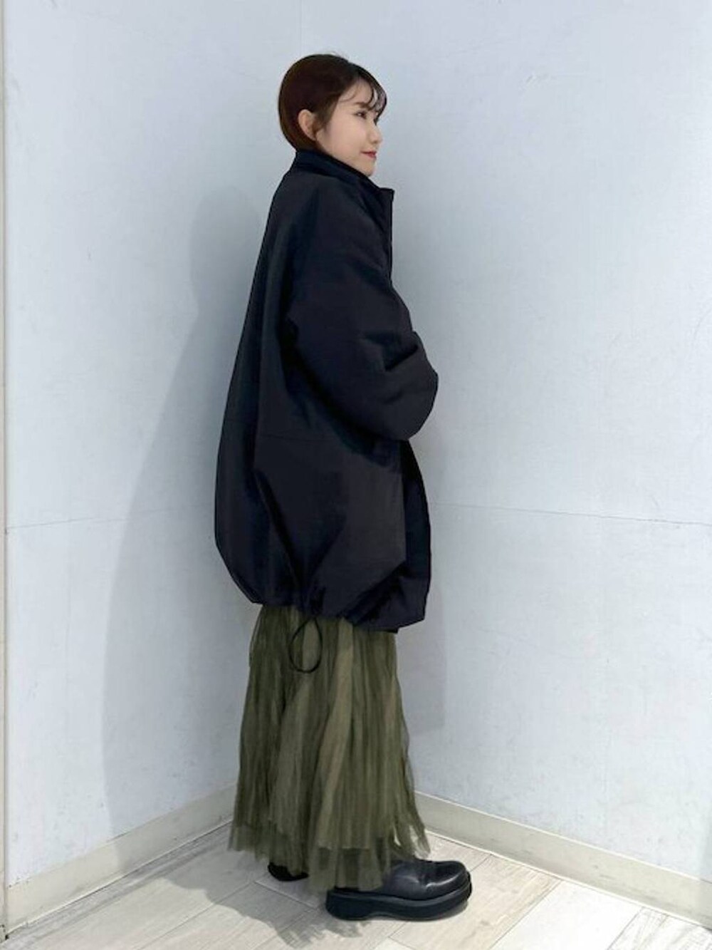 ブラック系のダウンジャケット/コート、ブラック系のブーツ、ホワイト系のTシャツ/カットソーを着用したレディースの冬コーディネートの7枚目の写真