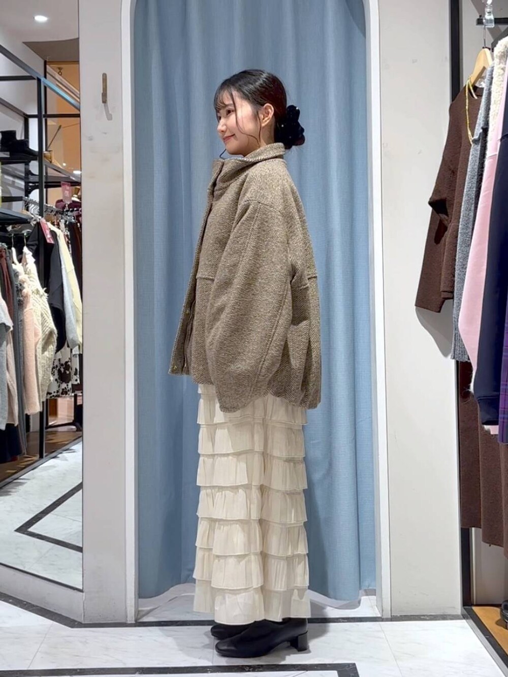 ベージュ系のブルゾン、ホワイト系のスカート、ブラウン系のニット/セーターを着用したレディースの冬コーディネートの7枚目の写真