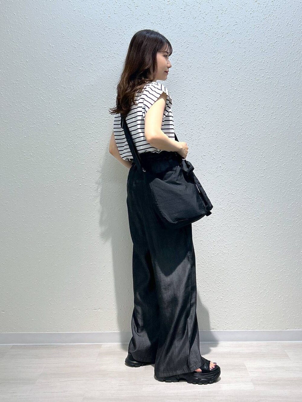 ブラック系のサンダル、ブラック系のデニムパンツ、ブラック系のTシャツ/カットソーを着用したレディースの夏コーディネートの6枚目の写真