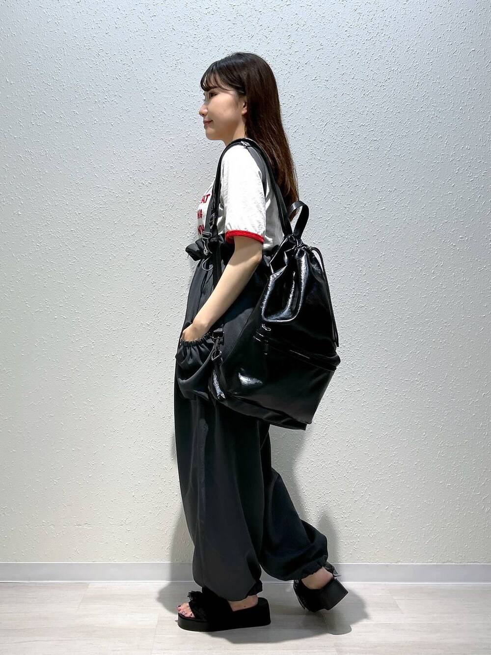 ブラック系のサンダル、ホワイト系のTシャツ/カットソー、ブラック系のショルダーバッグを着用したレディースの夏コーディネートの7枚目の写真