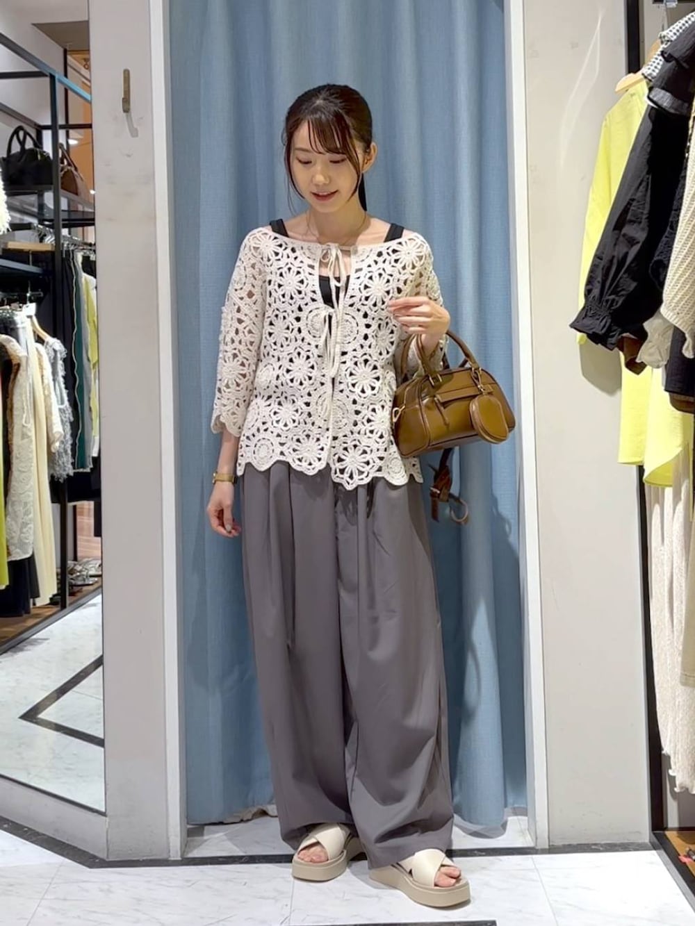 ブラック系のタンクトップ、ホワイト系のサンダル、ホワイト系のカーディガン/ボレロを着用したレディースの夏コーディネートの4枚目の写真