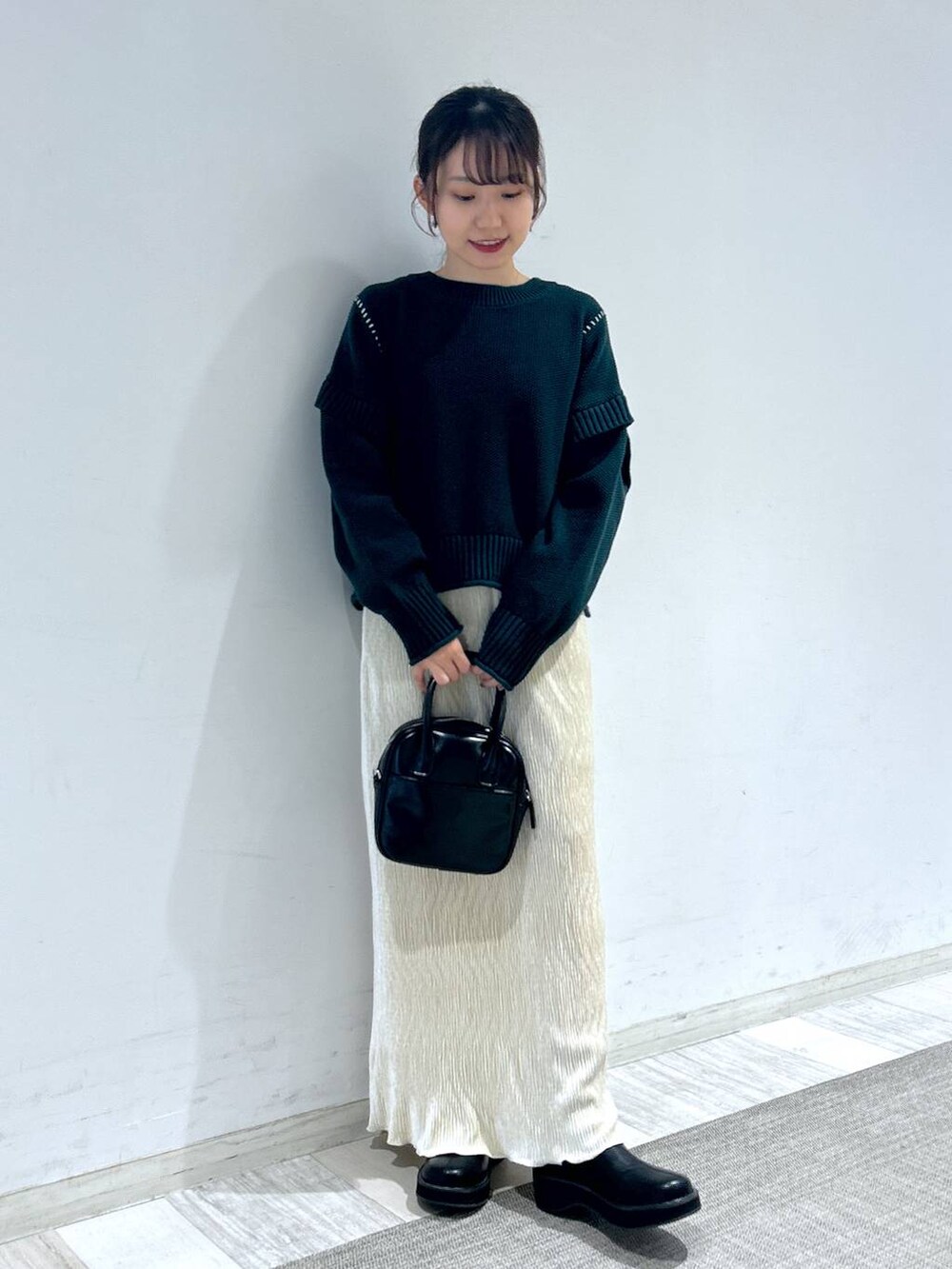 グリーン系のTシャツ/カットソー、ブラック系のブーツ、ブラック系のボストンバッグを着用したレディースの秋コーディネートの6枚目の写真