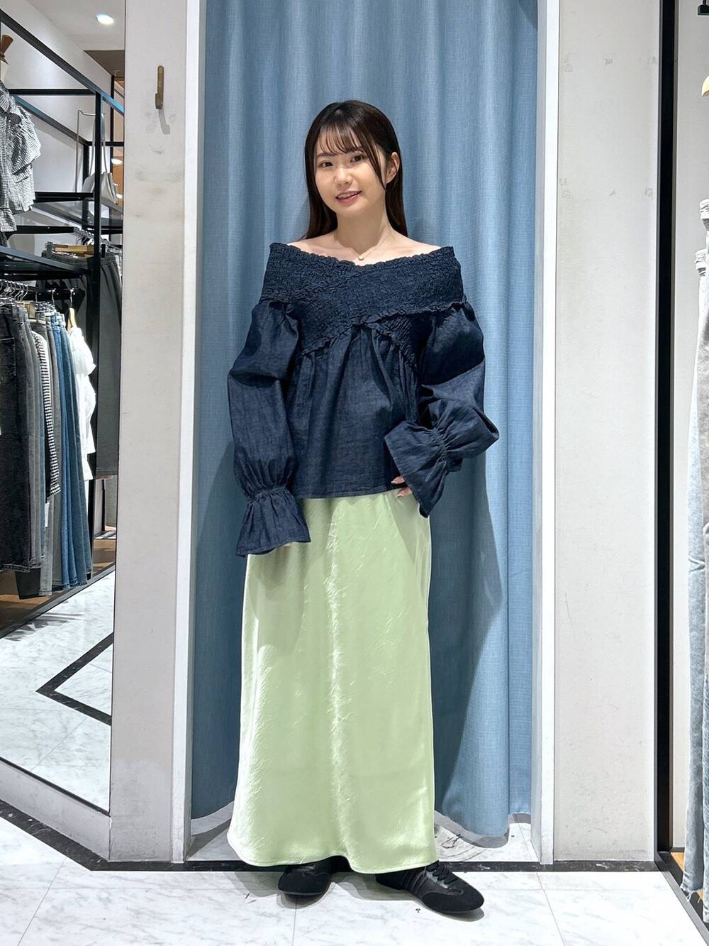 ブルー系のシャツ/ブラウス、ブラック系のスニーカー、グリーン系のスカートを着用したレディースの春コーディネートの3枚目の写真