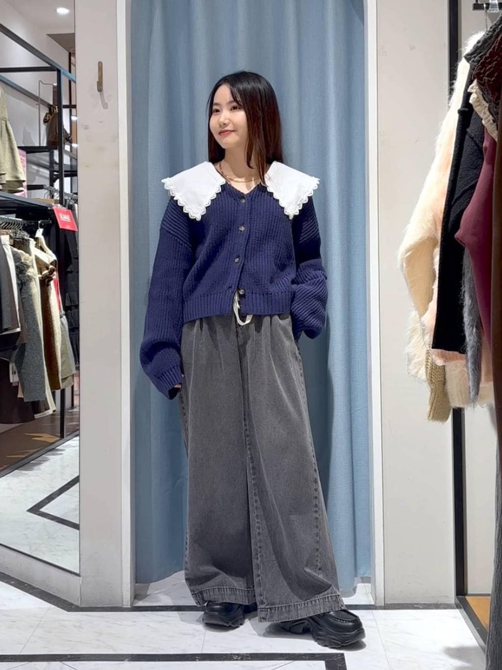 ブラック系のデニムパンツ、ブラック系のローファー、ブルー系のカーディガン/ボレロを着用したレディースの冬コーディネートの4枚目の写真