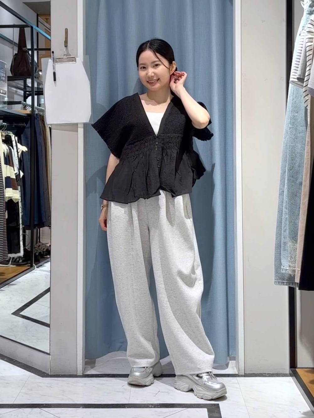 グレー系のスウェットパンツ、ブラック系のシャツ/ブラウス、シルバー系のスニーカーを着用したレディースの夏コーディネートの3枚目の写真