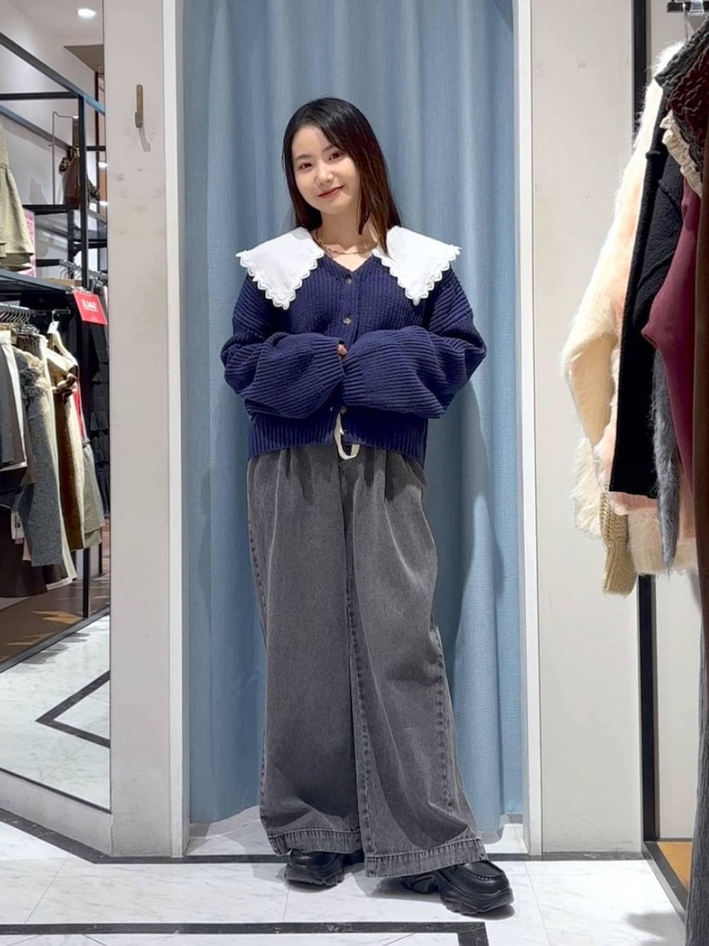 ブラック系のデニムパンツ、ブラック系のローファー、ブルー系のカーディガン/ボレロを着用したレディースの冬コーディネートの5枚目の写真