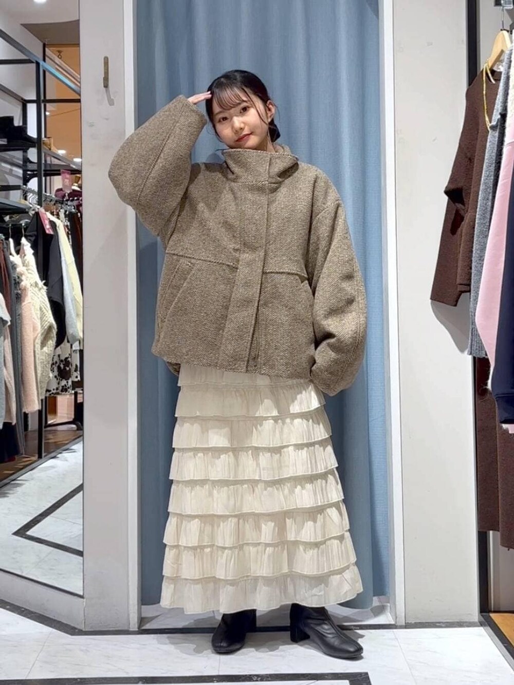 ベージュ系のブルゾン、ホワイト系のスカート、ブラウン系のニット/セーターを着用したレディースの冬コーディネートの5枚目の写真