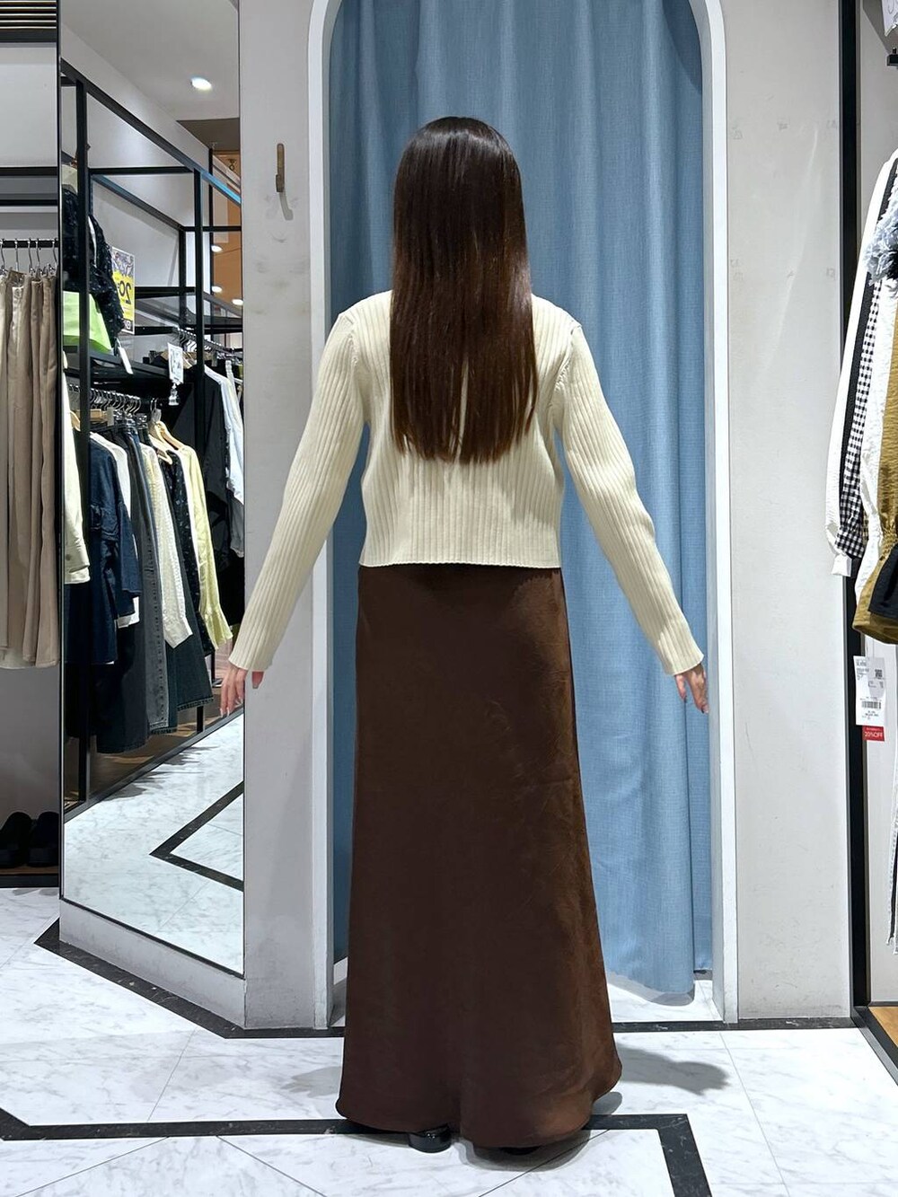 ホワイト系のカーディガン/ボレロ、ブラック系のパンプス、ゴールド系のタンクトップを着用したレディースの春コーディネートの9枚目の写真