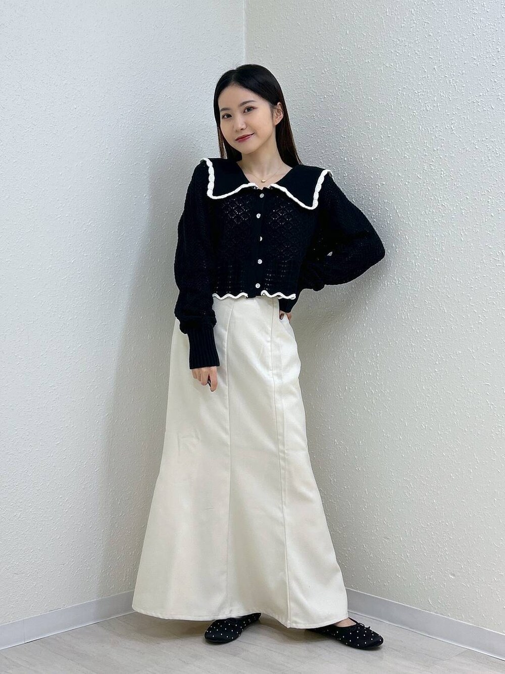 ホワイト系のスカート、ホワイト系のタンクトップ、ブラック系のバレエシューズを着用したレディースの秋コーディネートの6枚目の写真