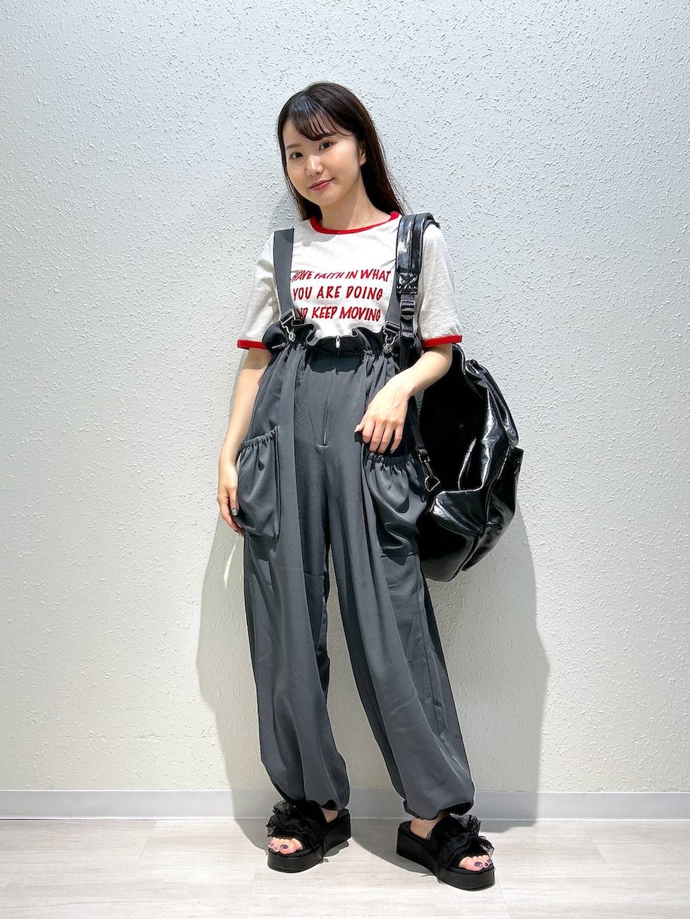 ブラック系のサンダル、ホワイト系のTシャツ/カットソー、ブラック系のショルダーバッグを着用したレディースの夏コーディネートの6枚目の写真