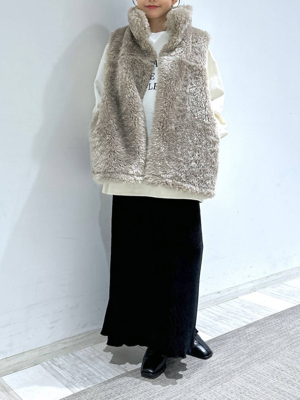 ホワイト系のブルゾン、ブラック系のパンプス、ブラック系のスカートを着用したレディースの冬コーディネートの5枚目の写真